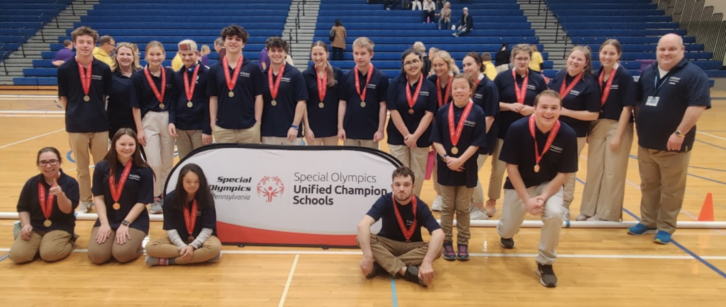 Special Olympics Bocce Team posing behind a special olympics sign